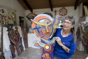 Betty LaDuke holding art