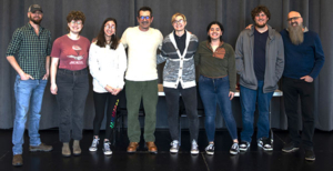 Group of people standing and smiling.