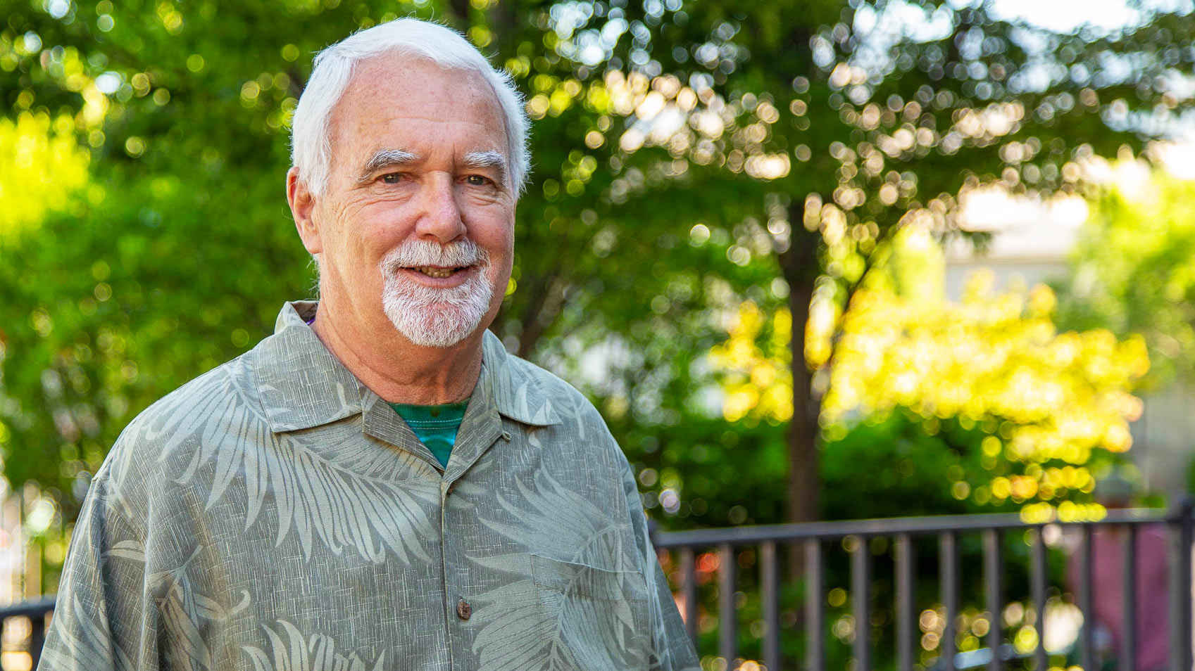 man smiling in front of trees